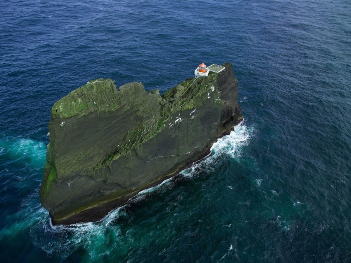 A lighthouse is located on a small island