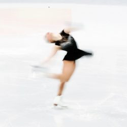 An ice skater is spinning about a vertical axis